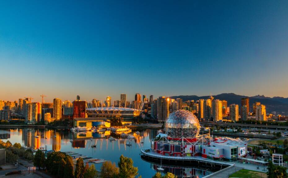 Vibrant sunset view of Vancouver's skyline, featuring Science World and cityscape reflections.